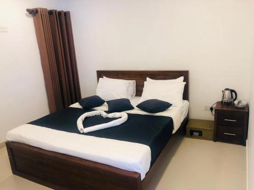 Cama con sábanas y almohadas azules y blancas en Little Heaven Villa, en Ambawela