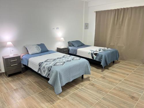 a bedroom with two beds and two night stands at Alvarez Apart in Ushuaia