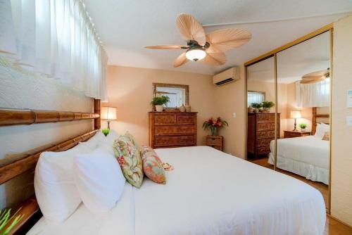 カハナにあるPapakea A301 · PK A301 BeachFront Corner Condo w Ocean Views Pooのベッドルーム(白いベッド1台、天井ファン付)