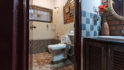 a bathroom with a toilet and a sink at Goshen in Bengaluru