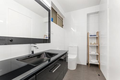 a bathroom with a sink and a toilet at Bay City (Geelong) Motel in Geelong
