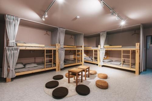 Una habitación con cuatro literas con mesa y sillas. en 稻禾棧, en Longtan