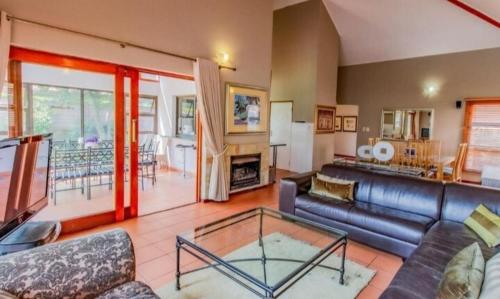 a living room with a couch and a glass table at Pecanwood Haven Hartbeesport Dam in Hartbeespoort