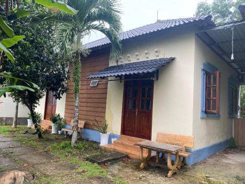 une petite maison avec un banc devant elle dans l'établissement Bungalow Tina, à Duong Dong