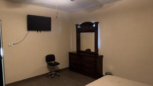 a bedroom with a mirror and a dresser and a television at Furnished apartment 10 minutes from the consulate in Manuel F. Martínez