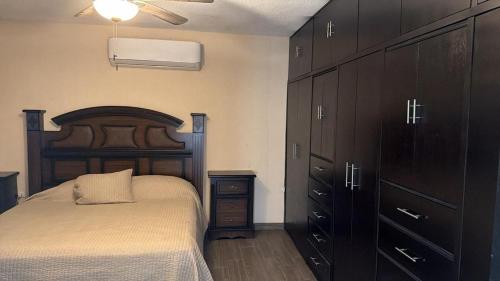 a bedroom with a bed and a dresser and cabinets at Furnished apartment 10 minutes from the consulate in Manuel F. Martínez