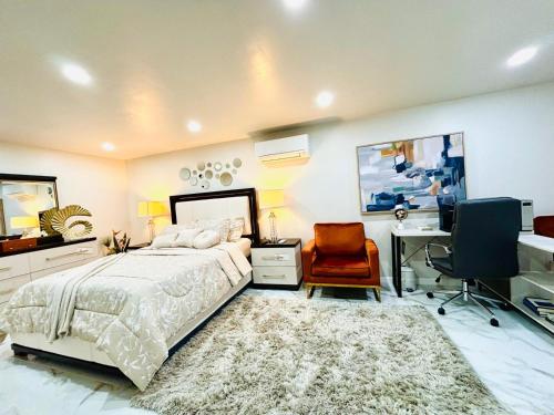una camera da letto con un letto, una scrivania e una sedia di Belmont Lux Escape a Elmont