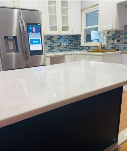 a kitchen with a white counter top and a refrigerator at Belmont Lux Escape in Elmont
