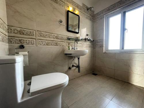 un baño con inodoro y lavabo en Hotel Vacation Home Kathmandu - Thamel, en Katmandú