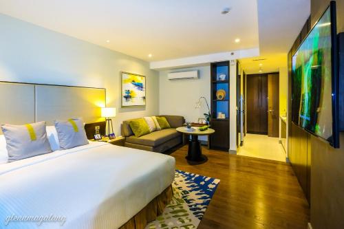 a hotel room with a large bed and a couch at Somerset Alabang Manila in Manila