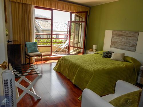 Un dormitorio con una cama verde y una ventana en Arriaga Marina Club Apartament, en Funchal