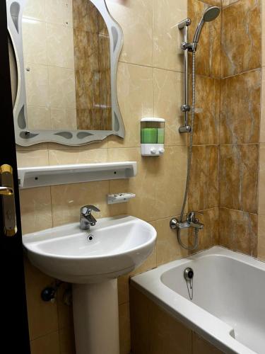 a bathroom with a sink and a mirror and a tub at Bliss Spot Vacation Homes in Al Ain