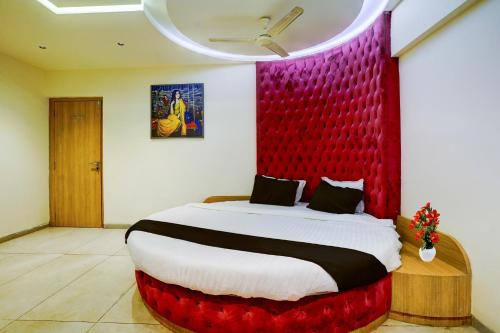 a bedroom with a large bed with a red headboard at Super Townhouse Oak New Nashik Highway Kalyan Bhiwandi in Kalyan