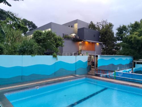 a house with a swimming pool and a fence at Ambu Guest House in Bandung