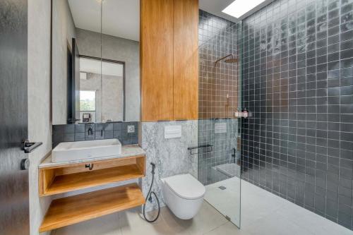 a bathroom with a sink and a toilet and a shower at Elourea 1BR Apt Rooftop Jacuzzi In Uluwatu in Uluwatu
