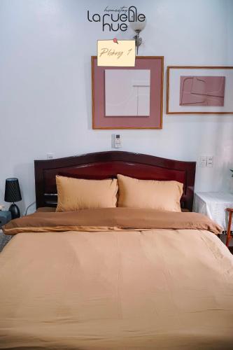 ein Schlafzimmer mit einem großen Bett mit einem Schild an der Wand in der Unterkunft La ruelle Huế homestay in Thôn Kim Long (1)