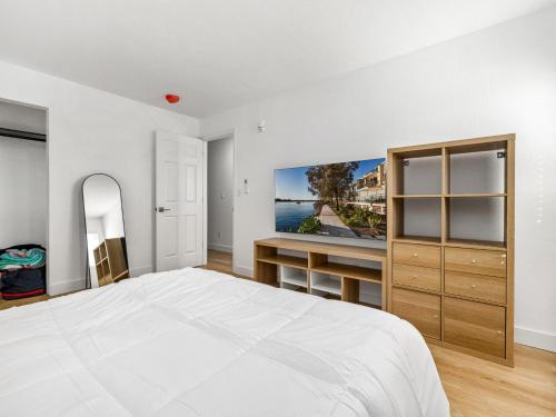a white bedroom with a bed and a desk at Casitas en Pueblo - Central Lofts in Pueblo