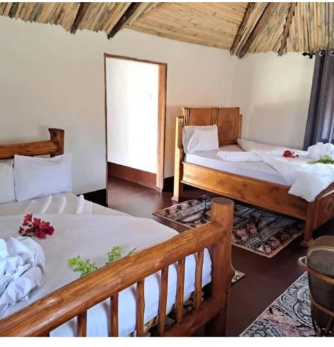 a room with two beds and a couch in it at LIMAS Camp Mikumi in Mikumi