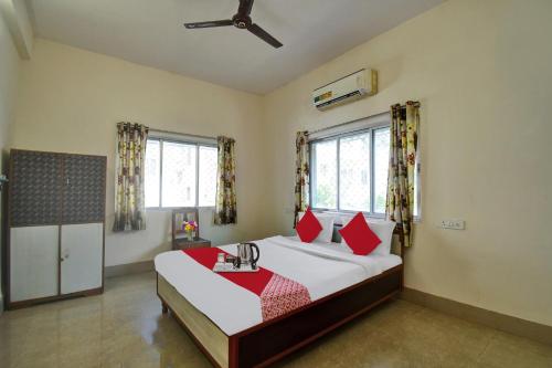 a bedroom with a large bed with red pillows at Hotel O Tumpa Inn in Kolkata