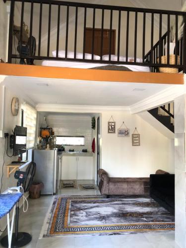a living room with a couch and a loft at Abe.Cottage 3 in Kampong Chawat