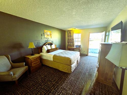a hotel room with a bed and a chair at Econo Lodge Eagle Nest in Eagle Nest