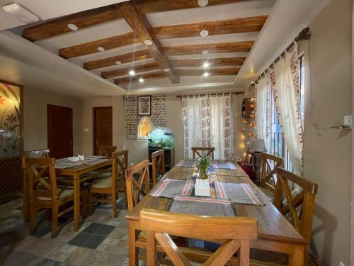 Un comedor con mesa y sillas de madera. en Hotel Vacation Home, en Katmandú