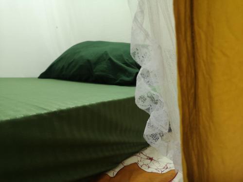 una persona in piedi accanto a un letto con una tenda di Hanuman Heights a Unawatuna