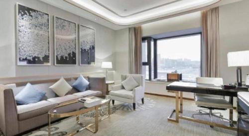 a living room with a couch and a piano at Wyndham Grand Plaza Royale Huayu Chongqing in Chongqing