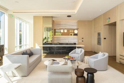 sala de estar con muebles blancos y cocina en Skyline Serenity Penthouse, en Los Ángeles