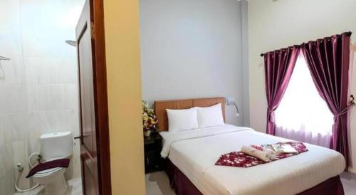 ジョグジャカルタにあるMalioboro Garden Hotel Yogyakartaのベッドルーム1室(ベッド1台付)、バスルーム(窓付)が備わります。