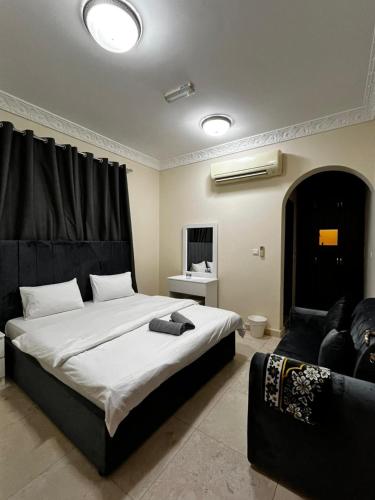 a bedroom with a large bed and a couch at Bliss Spot Vacation Homes in Al Ain