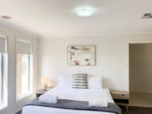a white bedroom with a bed and a window at Urban 3BR Oasis: Style & Comfort in Wagga Wagga