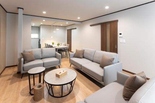 a living room with two couches and a table at Central Stay Sapporo 札幌中心部 最大24名 キッズルーム in Sapporo