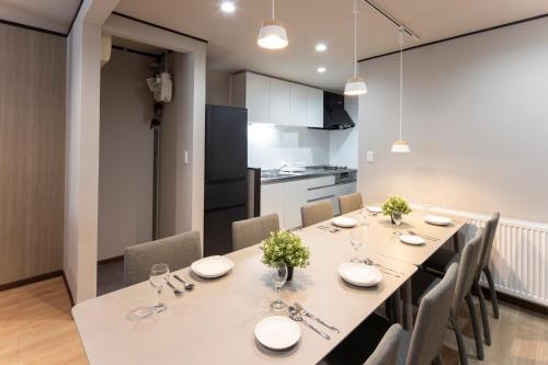 a kitchen and dining room with a table and chairs at Central Stay Sapporo 札幌中心部 最大24名 キッズルーム in Sapporo