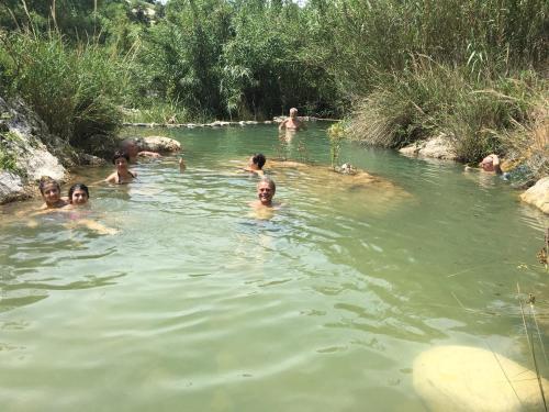 a group of people swimming in a river at Agriturismo Fontenuova in Saturnia