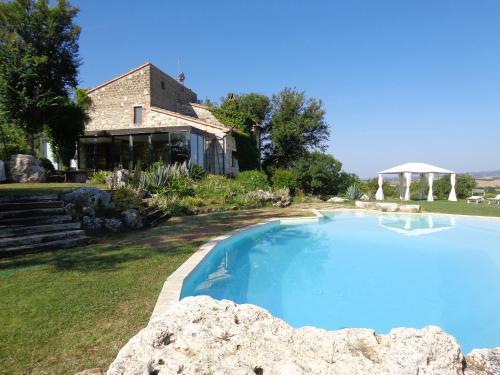 a large swimming pool in front of a house at Agriturismo Fontenuova in Saturnia