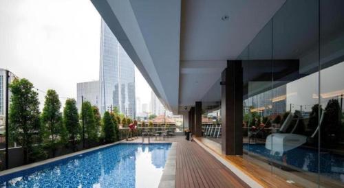 a large building with a swimming pool in a city at The Day Residence in Jakarta