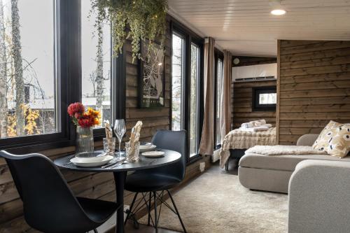 Una sala de estar con una mesa y sillas y un sofá. en Aava Riverside, en Rovaniemi