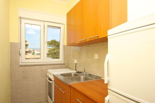 a small kitchen with a sink and a window at Apartments Eufemija in Novalja