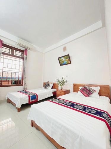 a bedroom with two beds and a window at Mai Chau Hostel in Mai Châu
