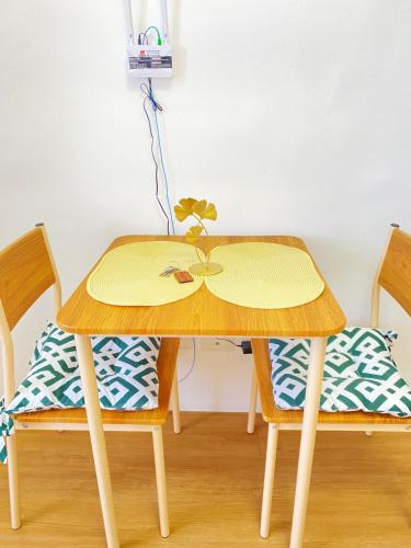 a wooden table with two chairs with a plant on it at Cozy Condo near Mactan Airport - Free Wifi! in Lapu Lapu City