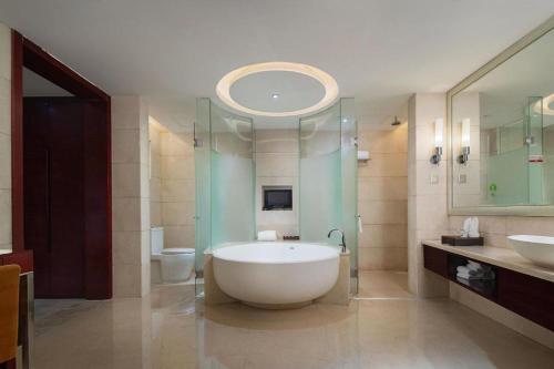 un bagno con vasca, lavandino e WC di White Swan Hotel ChangSha a Changsha