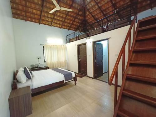 奇克马格尔Arabica Aura Homestay的一间卧室配有一张带吊扇的床和楼梯。