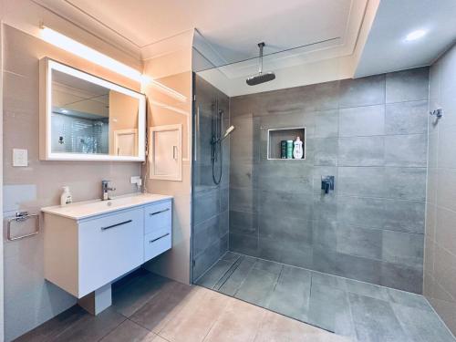 ein Badezimmer mit Dusche und Waschbecken in der Unterkunft Luxurious Homely Retreat in Springwood