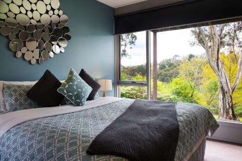 una camera da letto con un letto e una grande finestra di Daylesford Spa Villa 6 - 1 bedroom a Daylesford