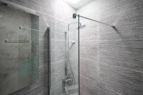 a shower with a glass door in a bathroom at Villa Orso Blue II in Ioulida