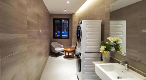 a bathroom with a white refrigerator and a sink at Yitel Collection Shenyang North Railway Station Metro Station in Shenyang