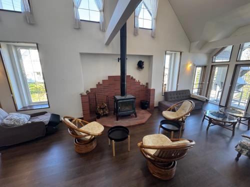 a living room with a fireplace and chairs at Pension Lavender in Furano