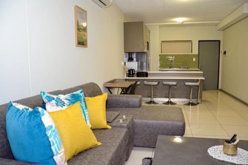 a living room with a couch and a kitchen at Platinum Heights Merensky in Windhoek