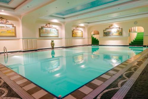 a large swimming pool in a hotel room with a large swimming pool at Hôtel Colbert - Spa & Casino in Antananarivo